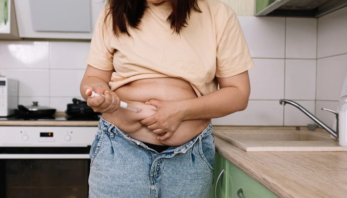1 de 1 Foto colorida de mulher em cozinha aplicando medicamento na barriga - Metrópoles - Foto: ...