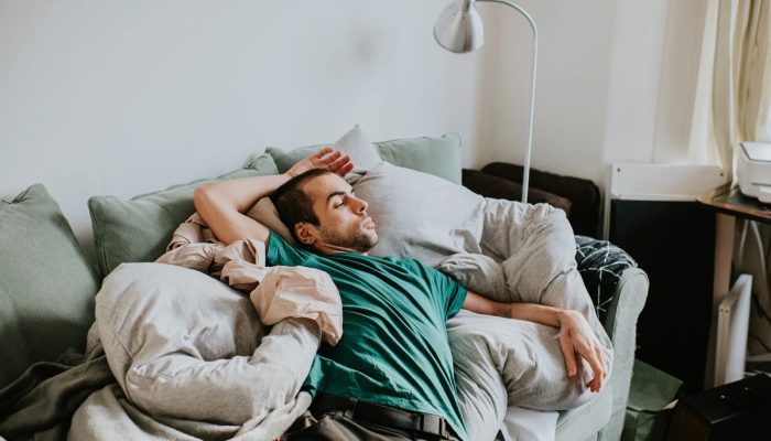 1 de 1 Um homem dorme sobre edredons e travesseiros em um sofá na sala de estar - Metrópoles - ...