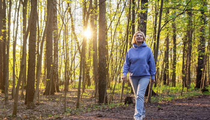 1 de 1 Mulher caminhando em um parque iluminado pelo sol ao pôr do sol na primavera - Metrópole...
