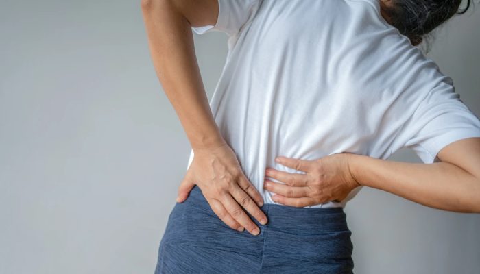 1 de 1 Mulher com dor lombar com mãos nas costas - Metrópoles - Foto: Boonchai Wedmakawand/ Get...