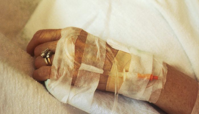 1 de 1 Foto colorida de mão feminina, idosa, com curativos e tubos hospitalares. Metrópoles. - ...