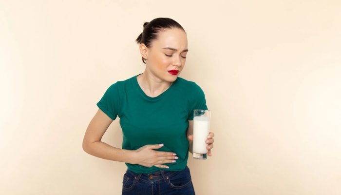 1 de 1 Mulher segurando um copo de leite e segurando a barriga- Metrópoles - Foto: Freepik