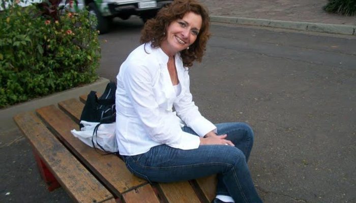 1 de 1 Foto colorida de mulher sentada em um banco na rua, sorrindo para foto - Metrópoles. - Fo...